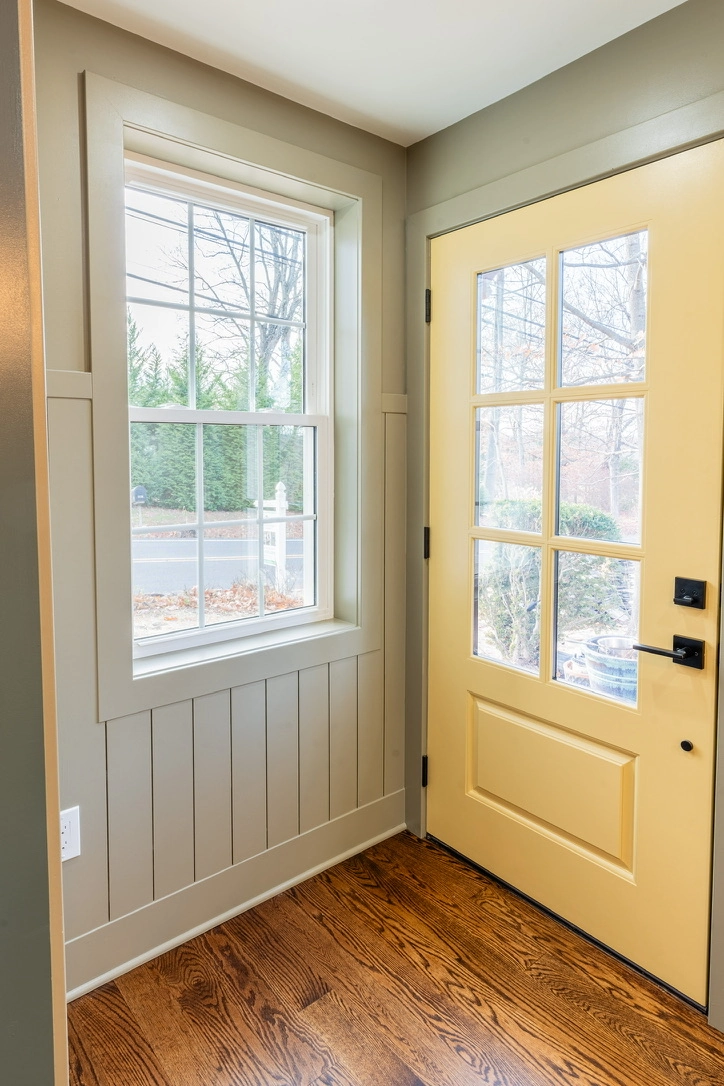 Entryway flooring installation with new hardwood floor, painted walls and installed window