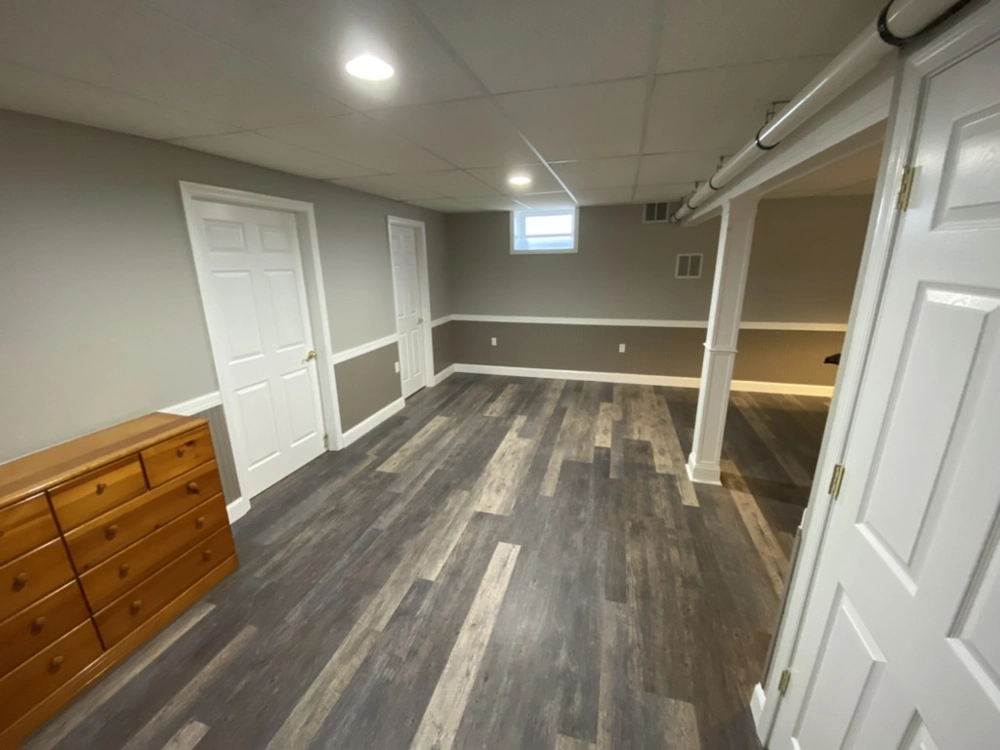 Finished basement interior with vinyl flooring, drop ceiling and painted walls, Basement Finishing