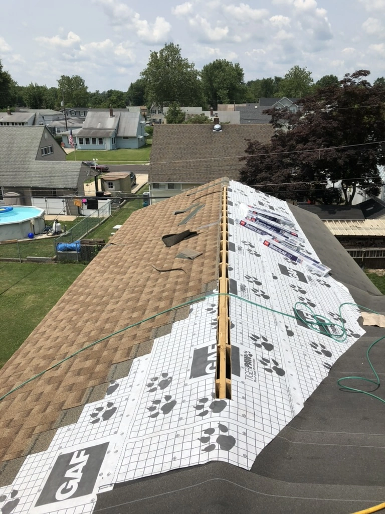 Shingle Roofing installation with underlayment and new asphalt shingles on residential roof