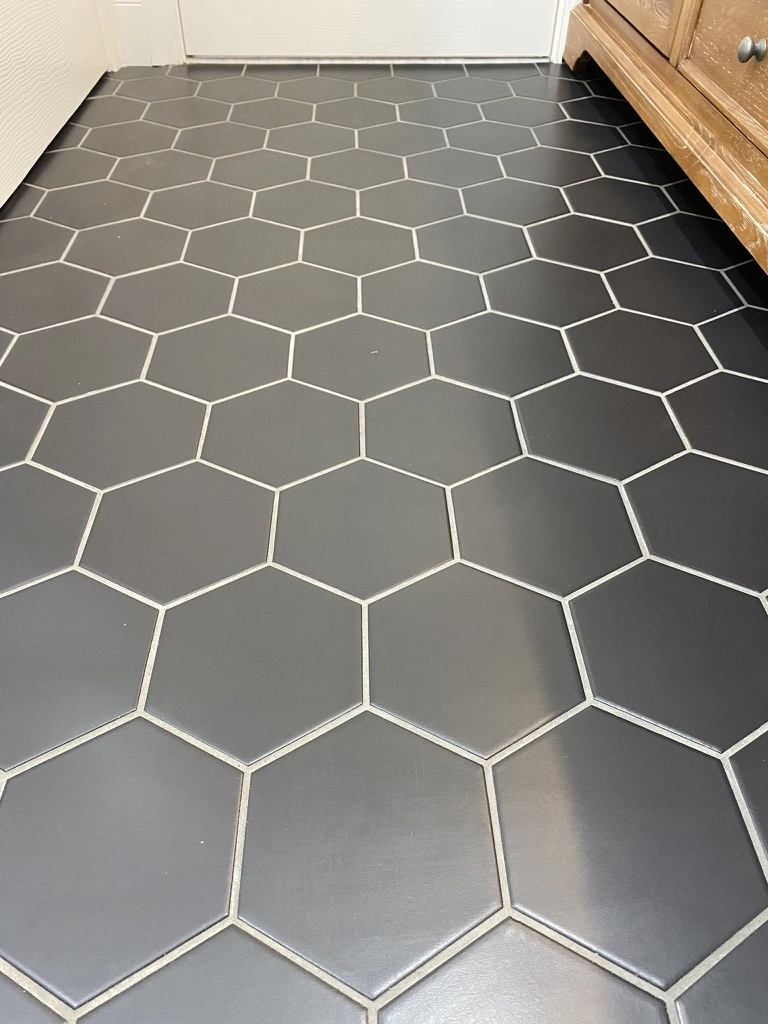 Black hexagonal floor tiles with contrasting white grout lines in a hallway – Tile Installation