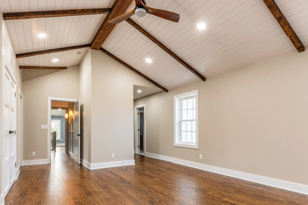 Empty renovated room with vaulted ceiling, ceiling fan, recessed lighting, beige walls, dark hardwood flooring – Hardwood Flooring