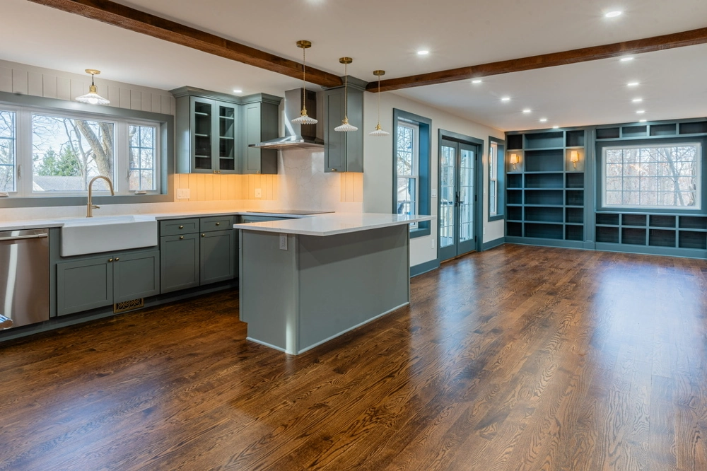 Kitchen Remodeling open concept kitchen with gray cabinets, center island, pendant lights, and new hardwood flooring