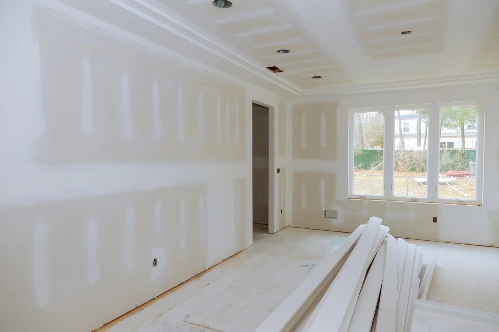 Interior room with freshly installed drywall panels and stacked boards ready for Drywall Installation