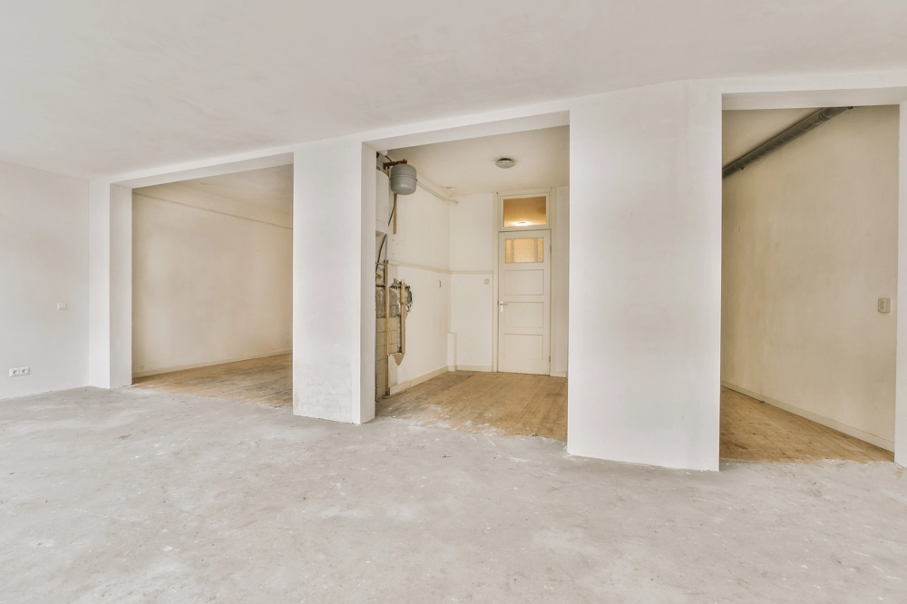 Interior space stripped to subfloor and partition walls ready for Home Renovation