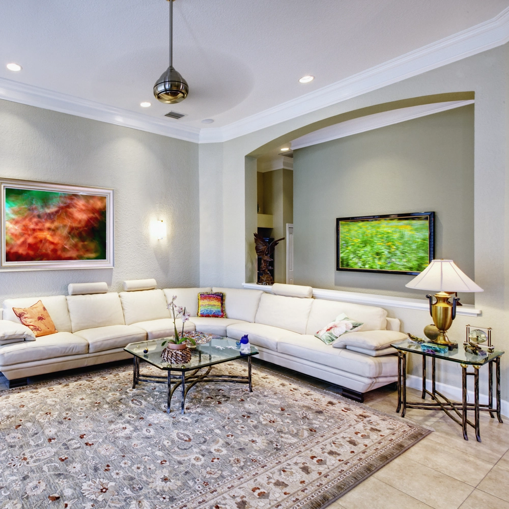 Modern living room showcasing Home Remodeling with cream sectional sofa, glass coffee table, decorative rug and accent lighting