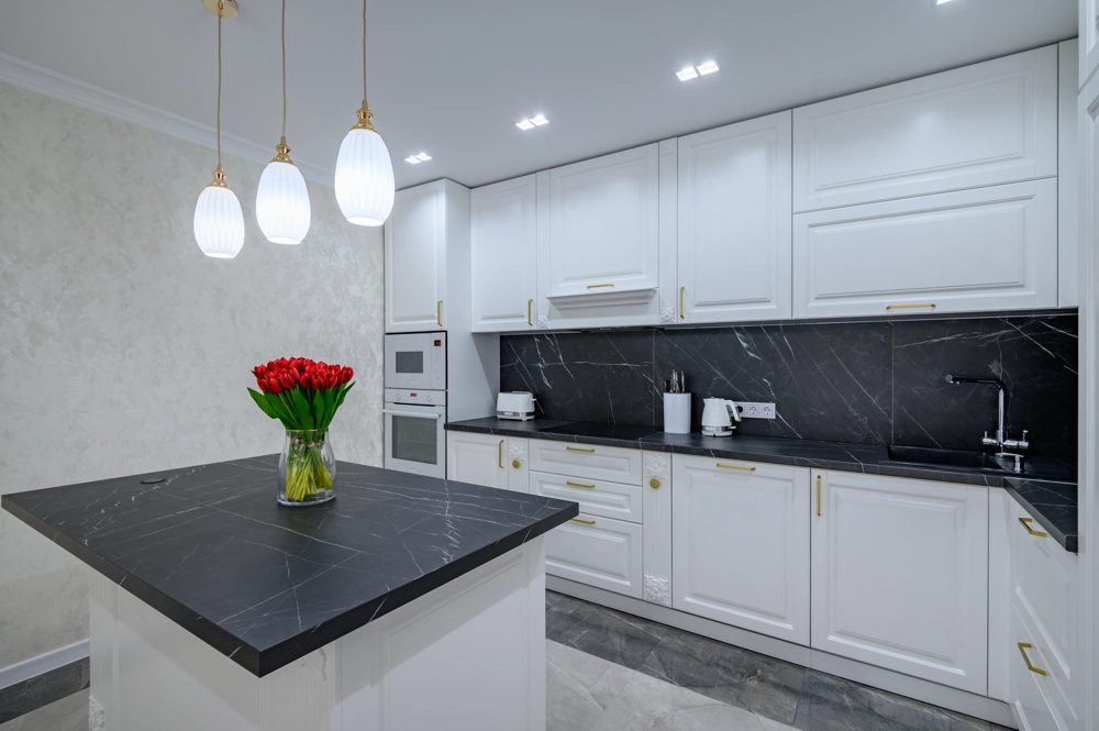 Modern remodeled kitchen with white shaker cabinets, black marble countertops, island and pendant lighting – Kitchen Remodeling