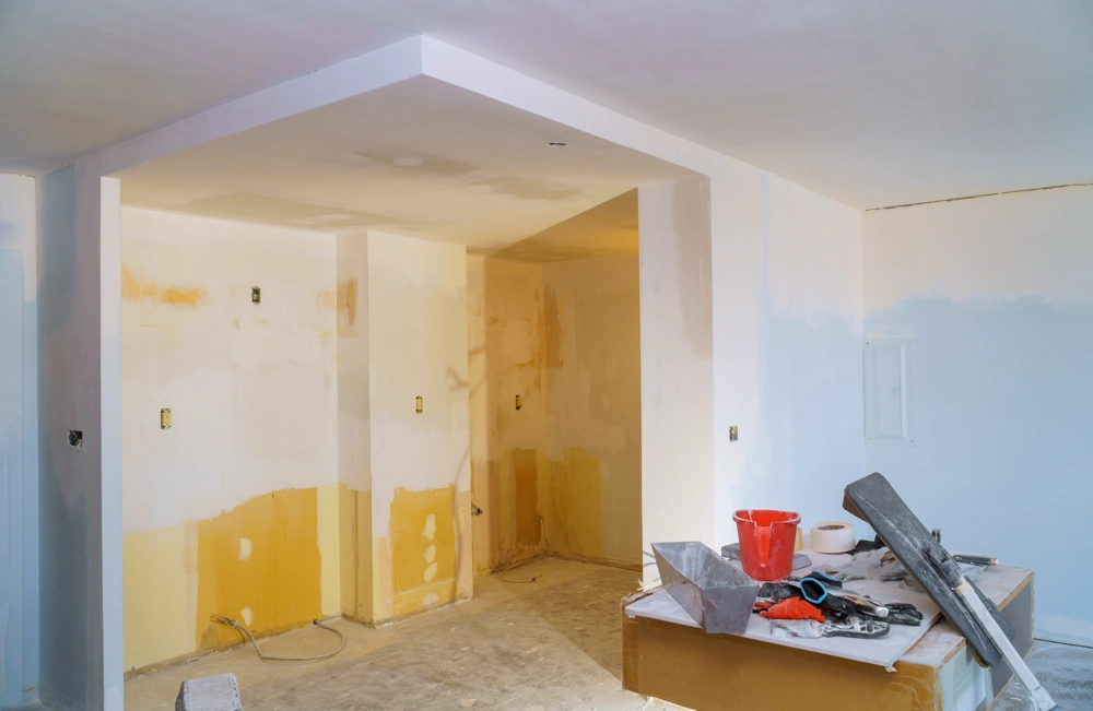Room under Drywall Installation with joint compound, drywall tools and bucket on workbench